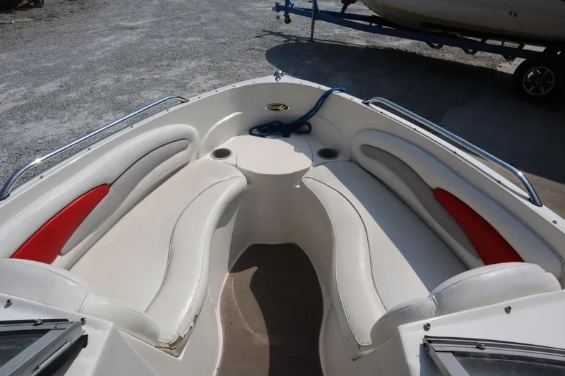 Slide: The Image of 2008 Stingray 195 LS/LX/LR boat interior with white and red seating, docked outdoors. - 7