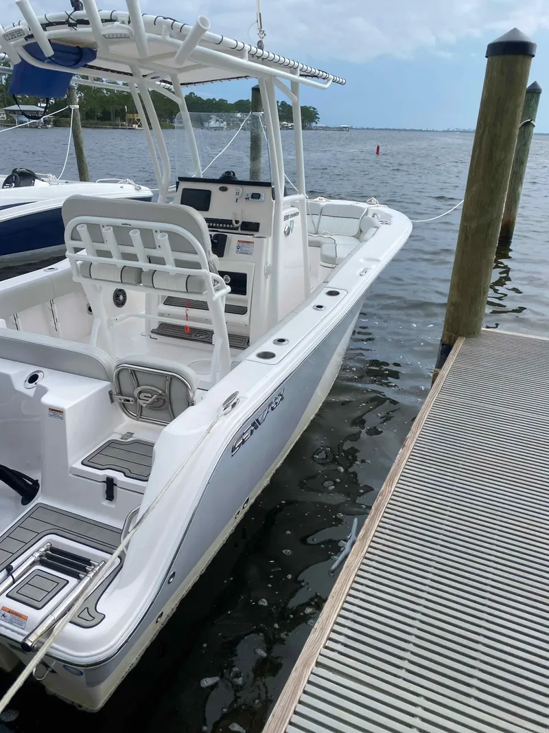 Slide: The Image of 2023 Sea Fox 228 Commander boat with sleek design and modern controls at dock. - 14