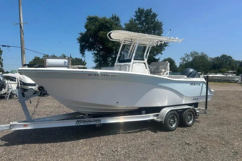 Slide: The Image of 2023 Sea Fox 228 Commander boat docked by a pier on a calm lake. - 22