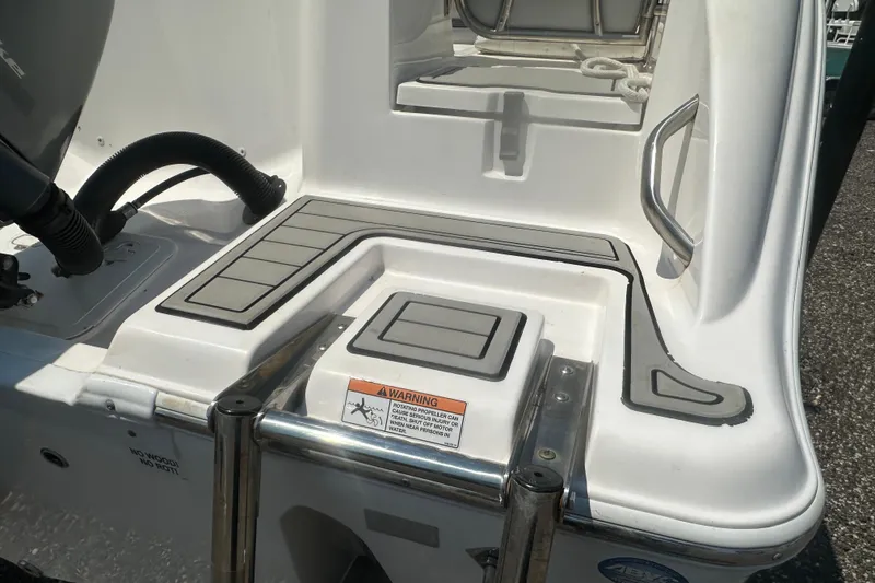 Slide: The Image of 2023 Sea Fox 228 Commander boat interior with seating and console, parked on gravel. - 31