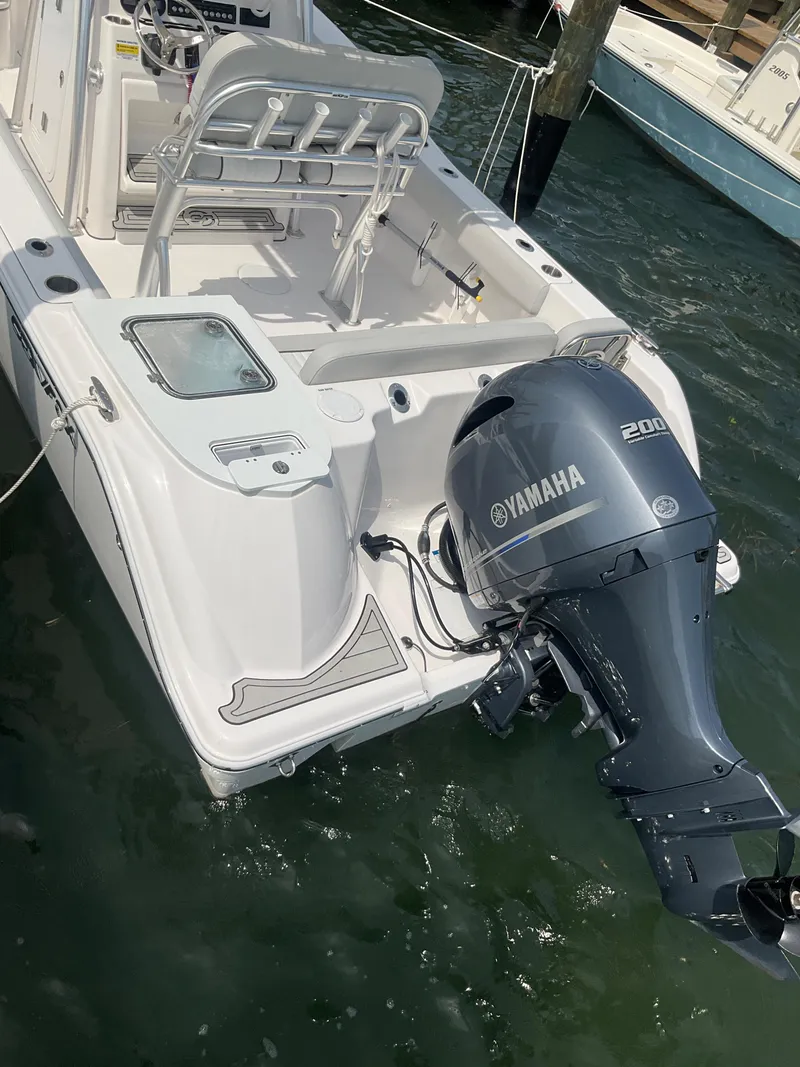 Slide: The Image of 2023 Sea Fox 228 Commander boat docked at a marina under a clear sky. - 9
