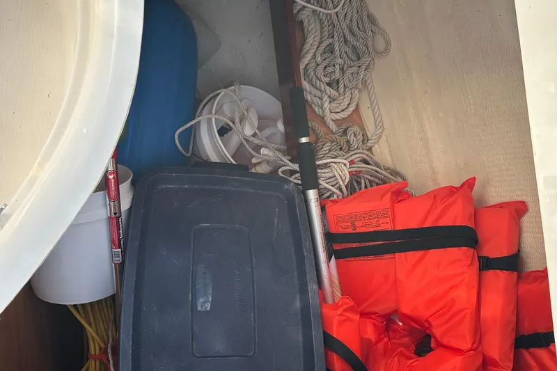 Slide: The Image of Storage compartment on a 2004 Beneteau 361 with life jackets, ropes, and equipment. - 14