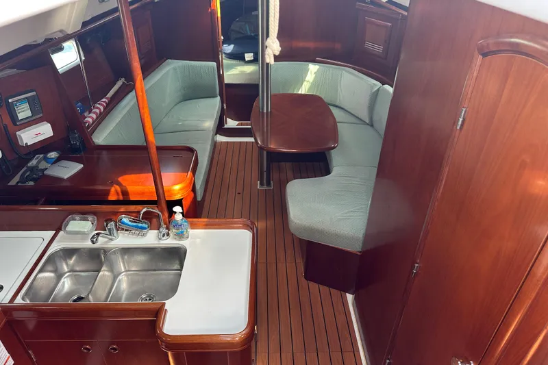 Slide: The Image of Interior of 2004 Beneteau 361 sailboat with wood finish and cozy seating area. - 18