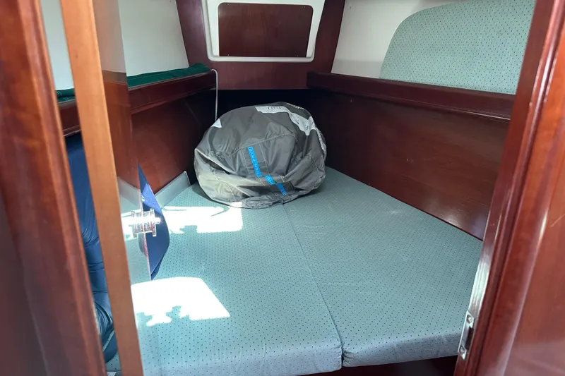 Slide: The Image of 2004 Beneteau 361 cabin interior with wooden finish and cushioned seating. - 20