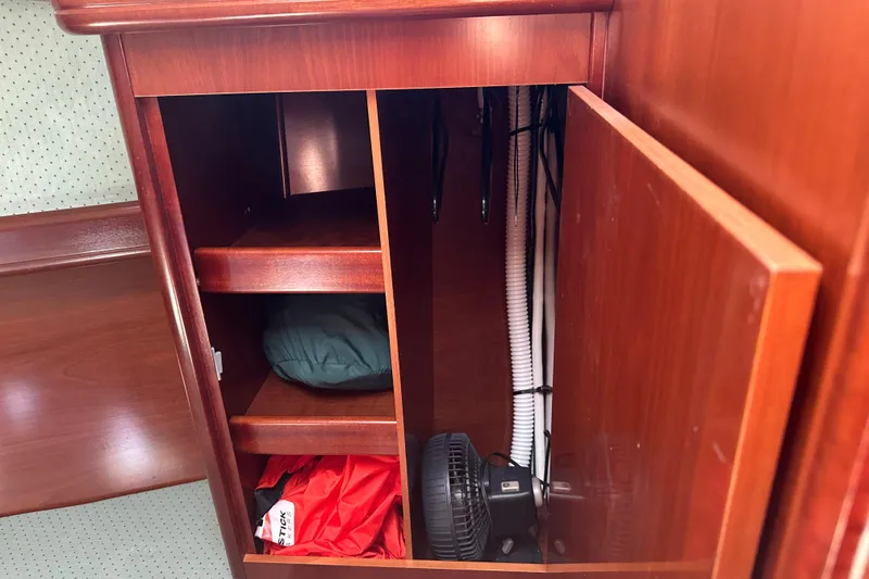 Slide: The Image of Interior storage cabinet on a 2004 Beneteau 361 sailboat, featuring shelves and a small fan. - 21
