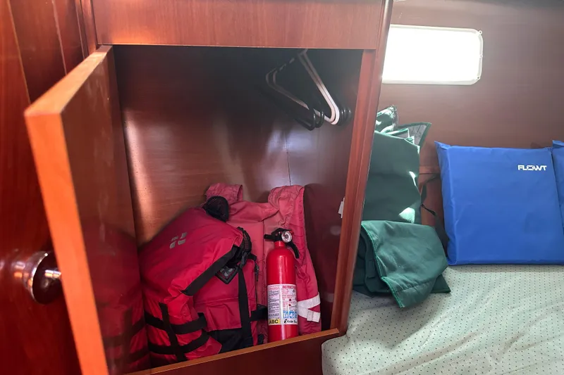 Slide: The Image of Cabin storage in 2004 Beneteau 361 sailboat with life jackets and fire extinguisher. - 23