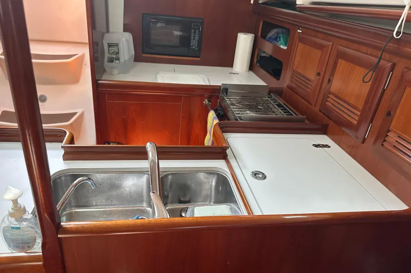 Slide: The Image of 2004 Beneteau 361 yacht kitchen with sink, stove, and microwave. - 25
