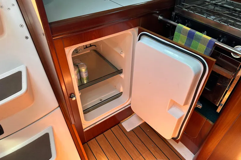 Slide: The Image of 2004 Beneteau 361 yacht interior with open fridge and wooden flooring. - 28