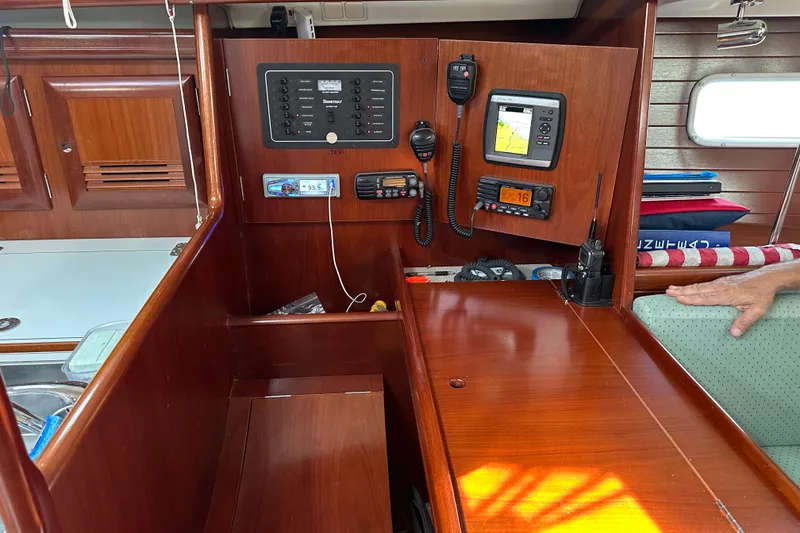 Slide: The Image of Interior of a 2004 Beneteau 361 sailboat with navigation equipment and wooden cabinetry. - 30