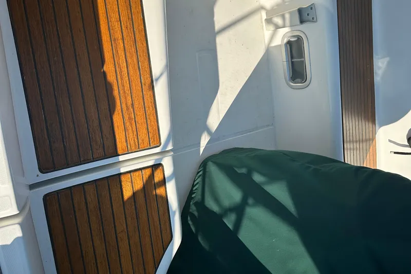 Slide: The Image of Interior of 2004 Beneteau 361 sailboat with wooden panels and green cover. - 7