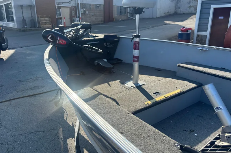 Slide: The Image of 2013 Lund 1600 Fury Tiller boat interior with seating and equipment, parked outdoors. - 3