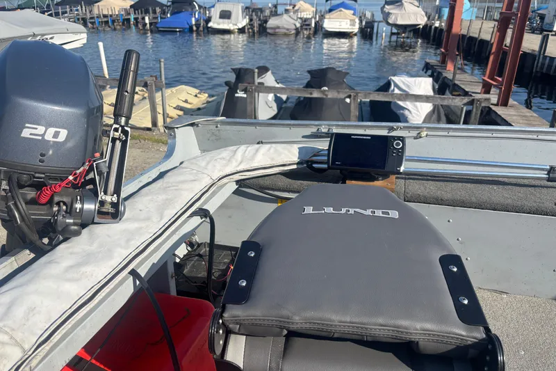 Slide: The Image of 2013 Lund 1600 Fury Tiller boat with motor, docked near other boats. - 9