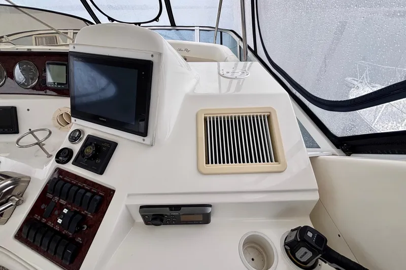 Slide: The Image of 2003 Sea Ray 480 Sedan Bridge helm with navigation controls and display screen. - 23