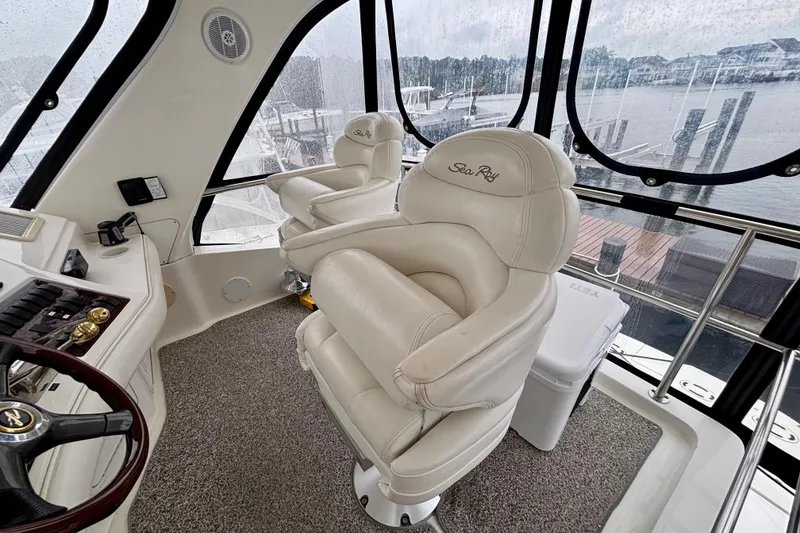 Slide: The Image of Interior of 2003 Sea Ray 480 Sedan Bridge with plush captain's chairs and panoramic windows. - 24