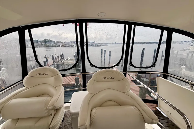 Slide: The Image of Interior view of 2003 Sea Ray 480 Sedan Bridge with marina backdrop. - 26