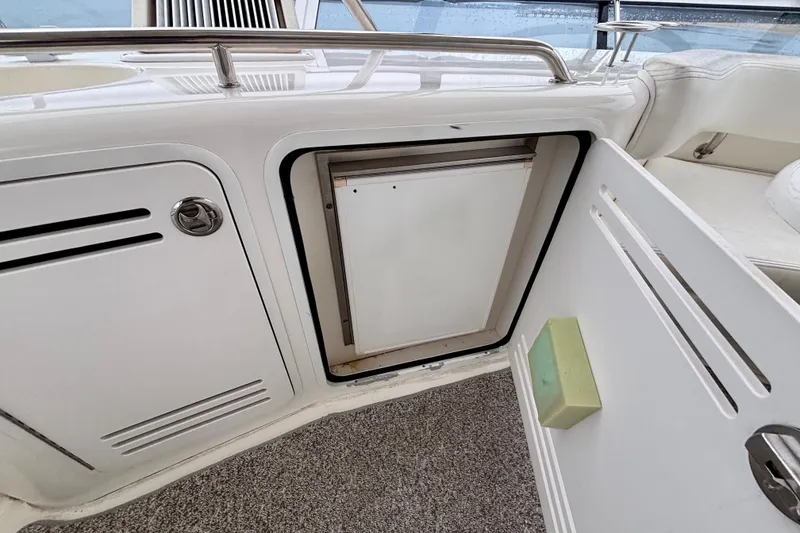 Slide: The Image of 2003 Sea Ray 480 Sedan Bridge interior with open storage compartment and seating area. - 29