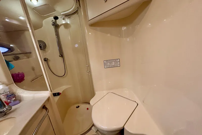 Slide: The Image of Bathroom interior of 2003 Sea Ray 480 Sedan Bridge yacht, featuring shower and toilet. - 35