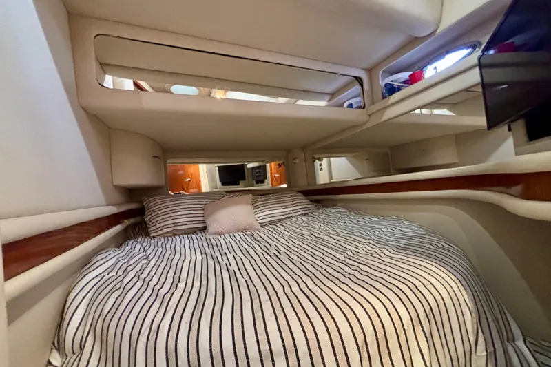 Slide: The Image of 2003 Sea Ray 480 Sedan Bridge cabin interior with striped bedding and modern design. - 37