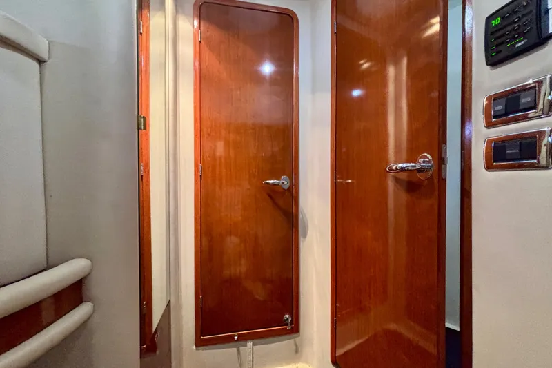 Slide: The Image of Interior view of 2003 Sea Ray 480 Sedan Bridge with wooden doors and control panel. - 39