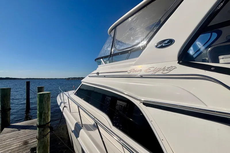 Slide: The Image of 2003 Sea Ray 480 Sedan Bridge yacht docked by the water on a sunny day. - 4