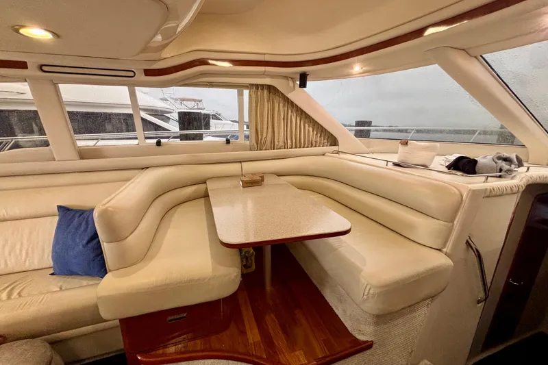 Slide: The Image of Luxurious interior of 2003 Sea Ray 480 Sedan Bridge yacht with plush seating and table. - 49