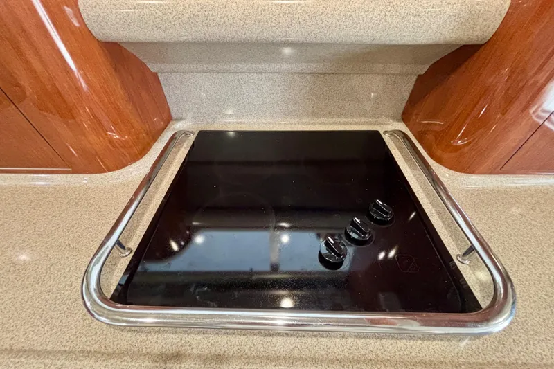 Slide: The Image of Stovetop in 2003 Sea Ray 480 Sedan Bridge yacht kitchen, featuring sleek black surface and controls. - 51