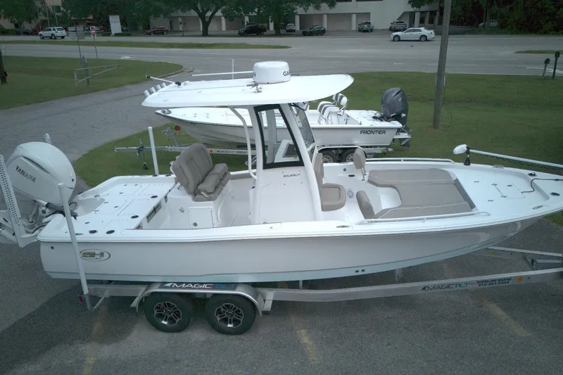 The Image of 2025 Sea Hunt BX 25 FS boat on trailer, side view, parked outdoors. - 1