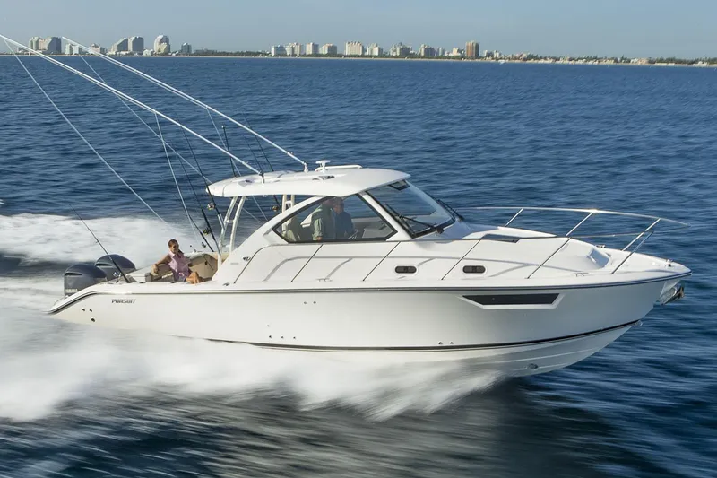 The Image of 2020 Pursuit OS 325 Offshore boat on trailer, parked outdoors under cloudy sky. - 0