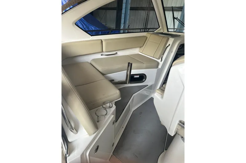 Slide: The Image of 2020 Pursuit OS 325 Offshore boat interior with beige seating and cup holders. - 10