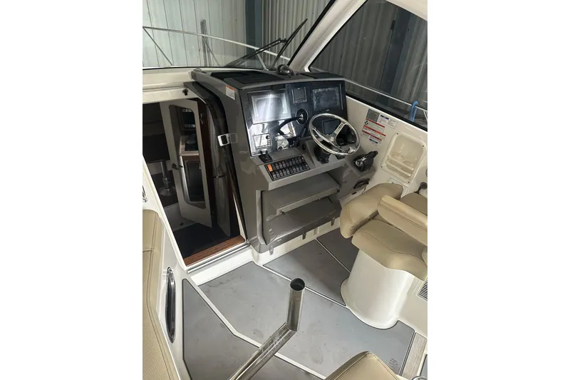 Slide: The Image of 2020 Pursuit OS 325 Offshore boat cockpit with steering wheel and navigation controls. - 12