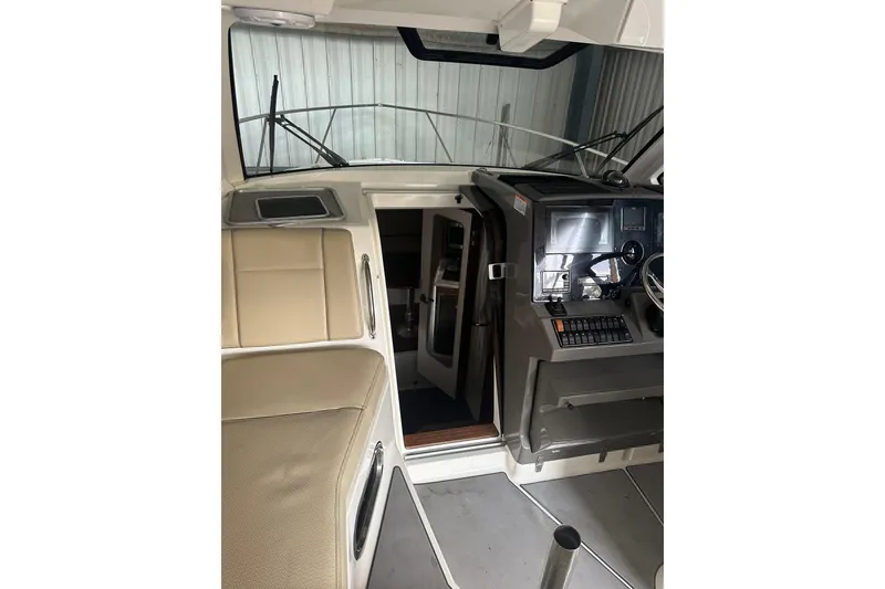 Slide: The Image of 2020 Pursuit OS 325 Offshore boat interior with helm and seating area. - 13