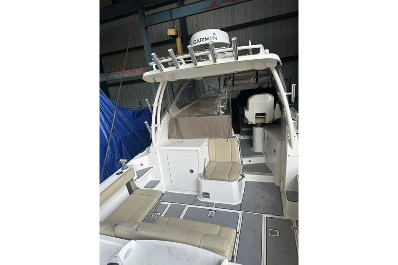 Slide: The Image of 2020 Pursuit OS 325 Offshore boat interior with seating and Garmin equipment. - 18