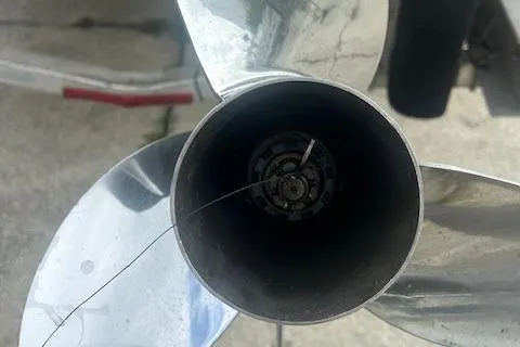 Slide: The Image of Close-up of a 2020 Pursuit OS 325 Offshore boat propeller with visible damage. - 5