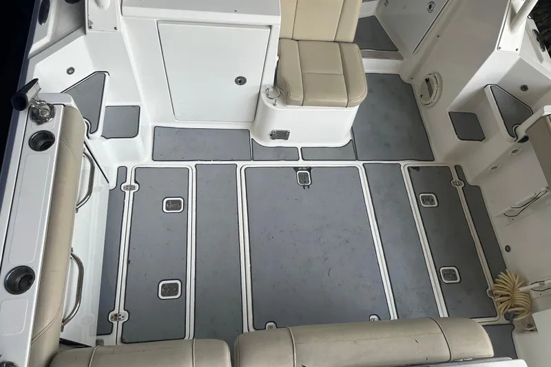 Slide: The Image of 2020 Pursuit OS 325 Offshore boat interior with cushioned seating and storage compartments. - 8