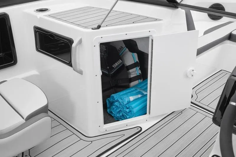 Slide: The Image of 2025 Yamaha Boats 195S storage compartment with life jackets and gear. - 3
