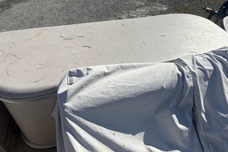 Slide: The Image of 2003 Aqua Patio 200RE boat with cover, showing weathered surface and outdoor setting. - 5