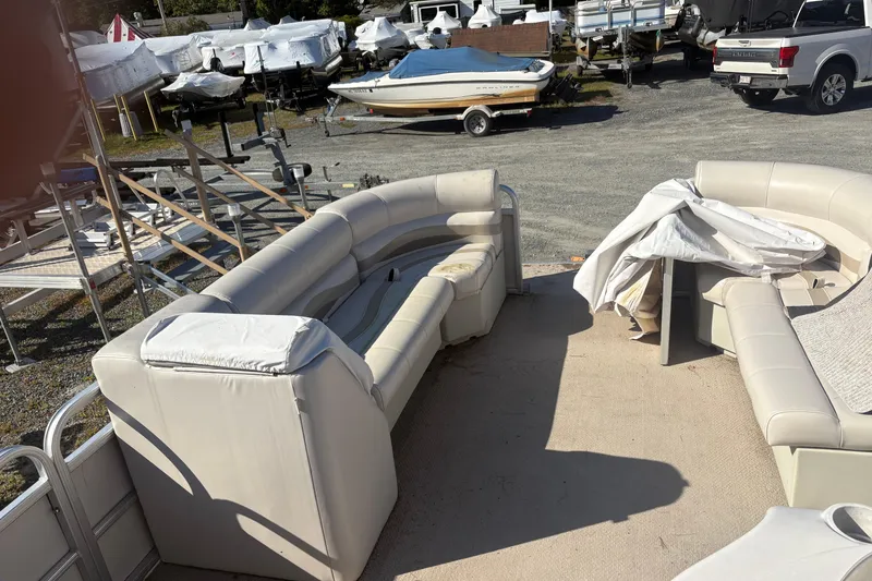 Slide: The Image of 2003 Aqua Patio 200RE pontoon boat with beige seating in a boatyard. - 6