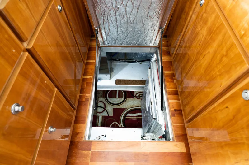 Slide: The Image of Wooden interior of 2006 Navigator 5100 yacht with open floor hatch revealing storage. - 12