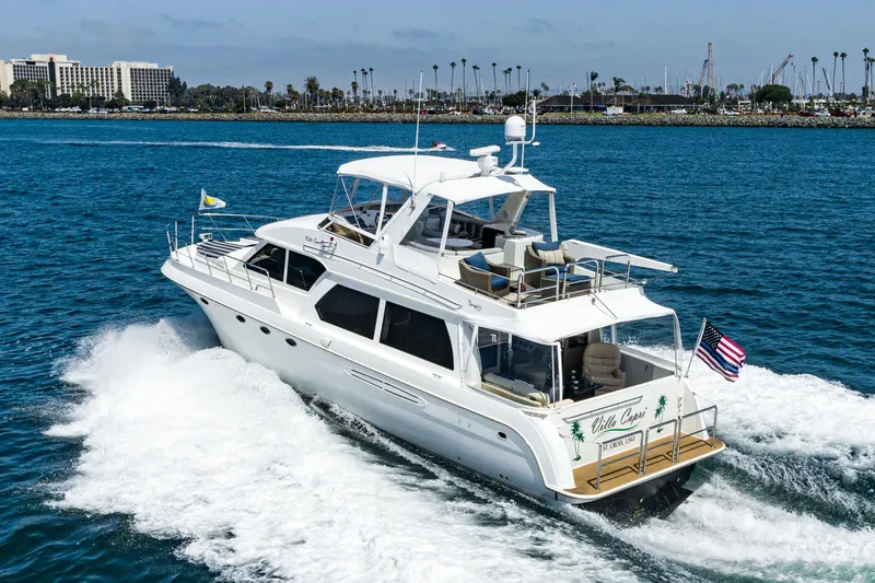 Slide: The Image of 2006 Navigator 5100 yacht cruising on blue ocean near coastal cityscape. - 2