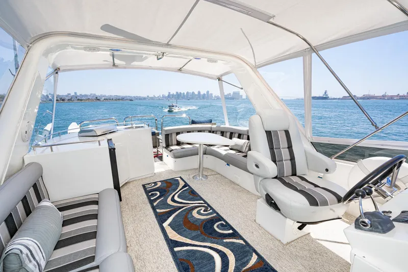 Slide: The Image of Luxurious 2006 Navigator 5100 yacht interior with striped seating, ocean view, and city skyline. - 20