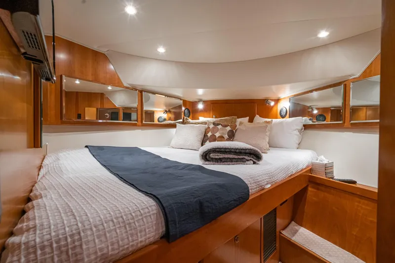 Slide: The Image of Luxurious cabin interior of 2006 Navigator 5100 yacht with cozy bedding and wooden accents. - 41