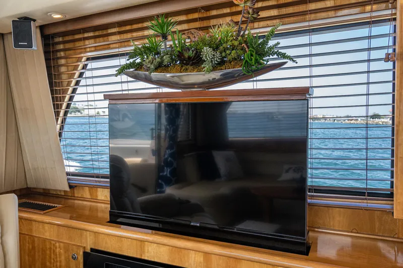 Slide: The Image of Luxurious 2006 Navigator 5100 yacht interior with TV, wooden blinds, and decorative plants. - 9