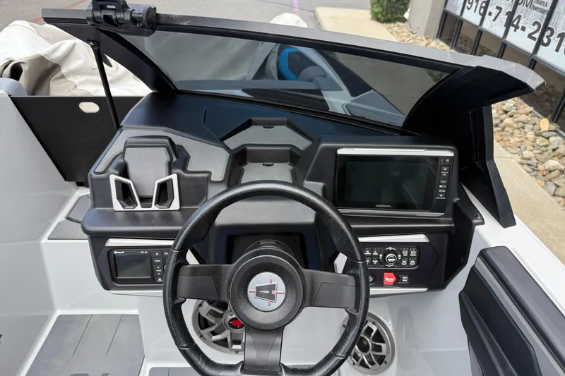 Slide: The Image of 2023 Axis A24 boat dashboard with steering wheel and navigation display. - 12