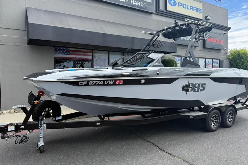 Slide: The Image of 2023 Axis A24 boat on trailer outside dealership, featuring sleek design and modern features. - 2