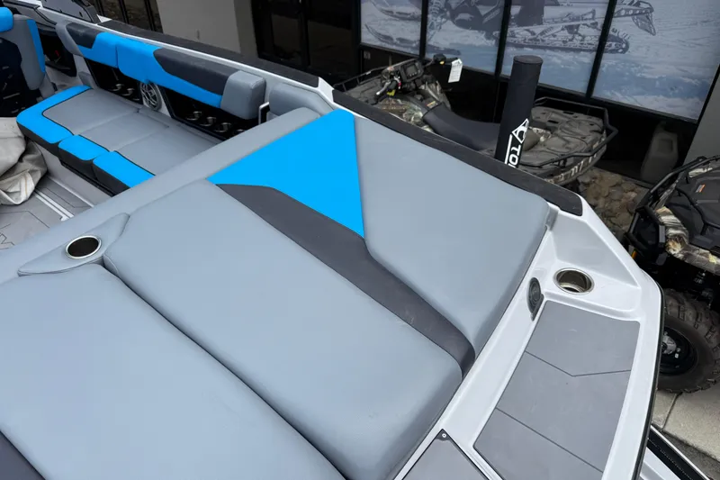 Slide: The Image of 2023 Axis A24 boat interior with blue and gray seating, cup holders, and modern design. - 28