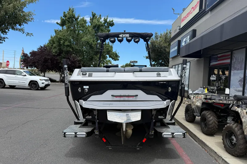 Slide: The Image of 2023 Axis A24 boat displayed outside dealership with vehicles and trees in background. - 4