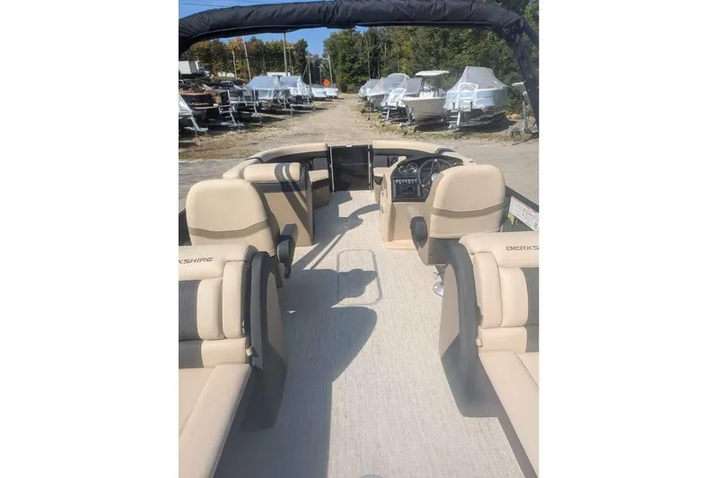 Slide: The Image of 2025 Berkshire 22RFX CTS pontoon boat interior with beige seating and steering console. - 6