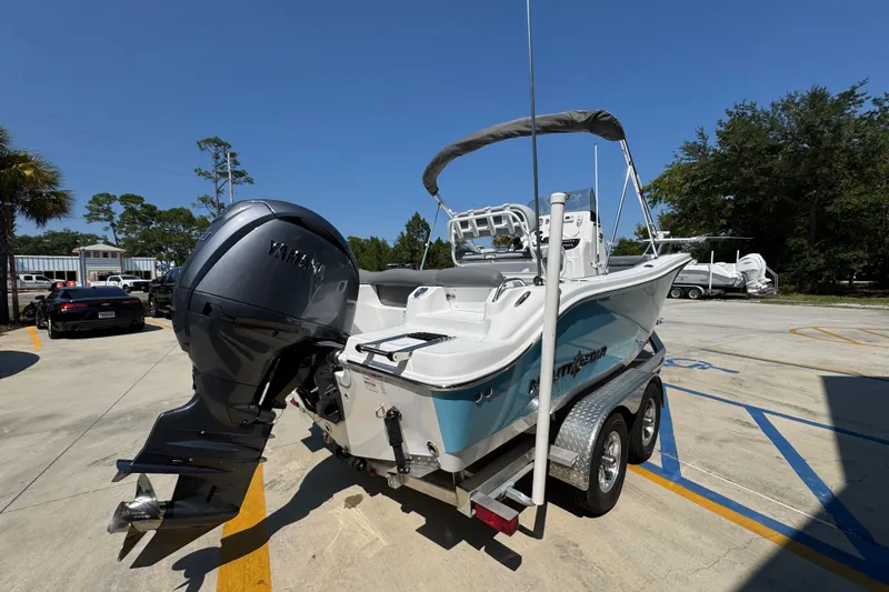 Slide: The Image of 2026 NauticStar 212 Legacy boat on trailer with Yamaha outboard motor in sunny parking lot. - 10