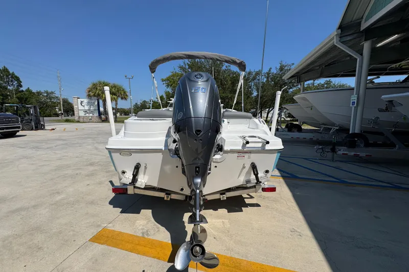 Slide: The Image of 2026 NauticStar 212 Legacy boat with outboard motor in a marina setting. - 12