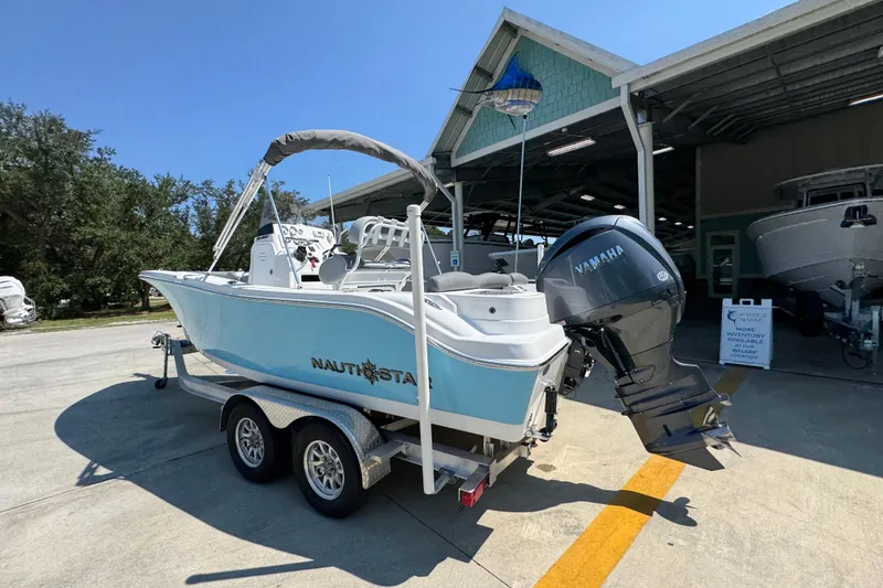 Slide: The Image of 2026 NauticStar 212 Legacy boat on trailer with Yamaha outboard motor. - 14
